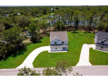 A beautiful home with fresh landscaping is nestled near a tranquil lake and lush green trees at 300 Mitnik Dr, Deltona, FL 32738