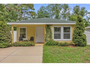 Charming single story home with a yellow exterior, lush greenery, and a welcoming front porch at 339 Chinaberry Ave, Oviedo, FL 32765