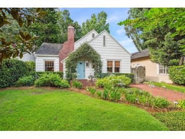 Charming cottage-style home with brick walkway, tidy landscaping, and a quaint blue door at 1008 Delaney Park Dr, Orlando, FL 32806