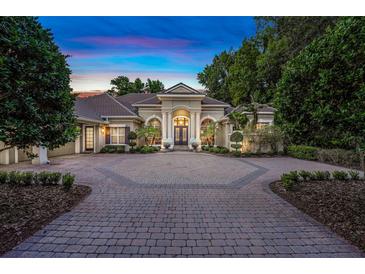 Stately home boasts lush landscaping and a circular brick driveway leading to its grand entrance at 1810 Oakbrook Dr, Longwood, FL 32779