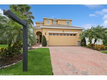 Charming two-story home with brick driveway and lush landscaping featuring mature palm trees at 2659 Magpie Way, Sanford, FL 32773