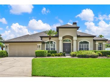 Stunning single-story home with a manicured lawn, arched entryway, and neutral color palette at 289 Laurenburg Ln, Ocoee, FL 34761