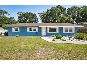 Charming blue single-story home featuring a well-manicured lawn and inviting curb appeal at 6663 Nw 60Th St, Ocala, FL 34482