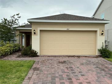 Charming single-story home featuring a brick driveway and a spacious two-car garage at 6841 Wilson Hammock Ave, Groveland, FL 34736