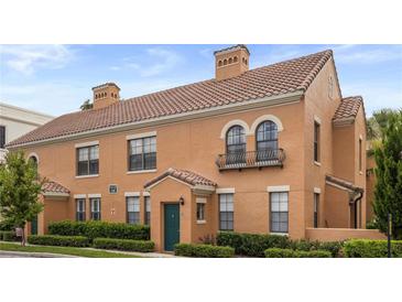 Charming two-story home with tile roof, green door, manicured landscaping, and stucco siding at 730 Siena Palm Dr # 201, Celebration, FL 34747
