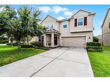 Charming two-story home with a manicured lawn, a two-car garage, and beautiful landscaping at 750 Maple Leaf Loop, Winter Springs, FL 32708