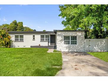 Charming single-story home with a well-manicured lawn and a mix of textured and smooth exterior finishes at 906 Kensington Dr, Orlando, FL 32808