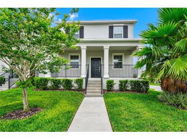 Charming two-story home with a welcoming front porch, manicured lawn, and lush landscaping at 9909 Alliteration Aly, Winter Garden, FL 34787