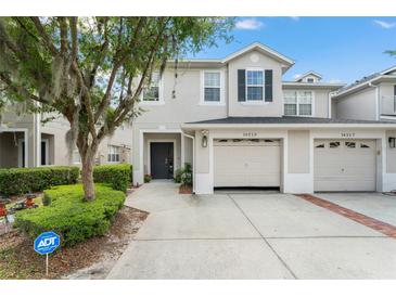 Well maintained two-story townhouse with a two-car garage and manicured landscaping at 14213 Turning Leaf Dr, Orlando, FL 32828