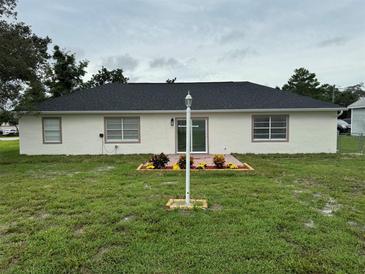 An outdoor view of the home with a lush lawn and a charming patio area for relaxation at 2864 Trenton Ln, Deltona, FL 32738