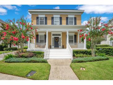Charming two-story home with a welcoming front porch, classic columns, and beautiful landscaping at 4065 Anissa Ave, Orlando, FL 32814