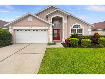 Charming single-Gathering home with red double-door entry, manicured lawn, and two car garage at 5231 Alavista Dr, Orlando, FL 32837