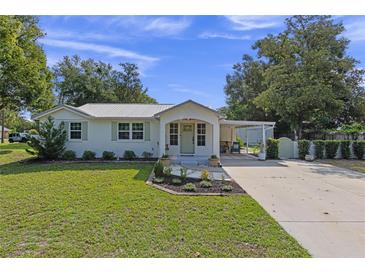 Charming single story home with metal roof, covered entry and carport, and manicured front lawn at 63 Madera Rd, Debary, FL 32713