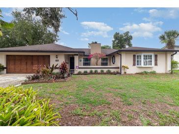 Charming single-story home featuring a well-maintained front yard and a two-car garage at 7058 Archwood Dr, Orlando, FL 32819