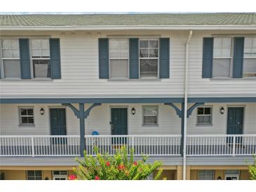 Charming two-story condo featuring a lovely porch and blue trim on the windows and supports at 720 Celebration Ave # 245, Kissimmee, FL 34747