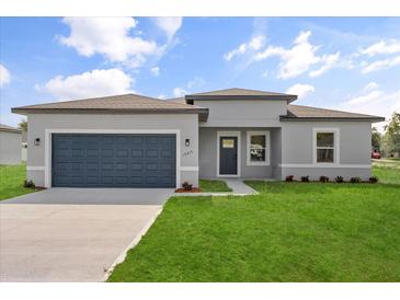 Charming single-story home featuring a well-manicured lawn and a two-car garage, perfect for Gathering living at 14915 Sw 39Th Cir, Ocala, FL 34473