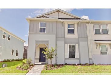 Charming townhome showcasing a two-story facade, manicured lawn, and welcoming front entrance at 16129 Palm Frond Ave, Clermont, FL 34714