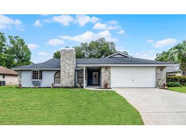 Charming single-story home with a stone facade, attached two-car garage, and well-maintained lawn at 229 Marcum Trace Dr, Lakeland, FL 33809