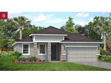 Charming single-story home featuring stone accents, a two-car garage, and professionally landscaped front yard at 2292 Sirena Ln, Mount Dora, FL 32757