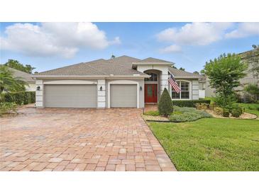 Charming single-story home with a well-manicured lawn, brick driveway and two car garage at 405 Courtlea Park Dr, Winter Garden, FL 34787