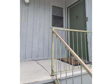 Entryway with a weathered green door and matching railing, creating a vintage exterior at 4371 Aqua Vista Dr # G, Orlando, FL 32839