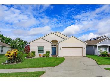 Charming single-story home featuring a well-manicured lawn and two car garage under a sunny sky at 4642 Waterside Pointe Cir, Orlando, FL 32829