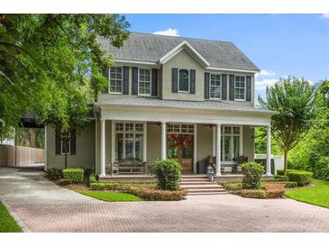 Stately two-story home with a welcoming front porch, beautiful landscaping, and a brick driveway at 685 Mayo Ave, Maitland, FL 32751