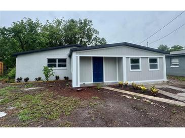 Charming single story home featuring a blue door, fresh exterior paint and landscaping at 8320 Dominguin St, Orlando, FL 32817