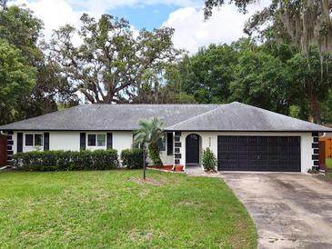 Charming single-story home features a well-manicured lawn and a two-car garage in a tranquil neighborhood at 8404 Singapore Ct, Orlando, FL 32817