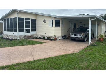 Charming manufactured home with cozy carport and screened-in porch offering comfortable outdoor living at 125 Darlene Ct, Davenport, FL 33897