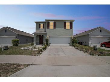 Charming two-story home with a two-car garage and well-maintained front yard at 129 Eagleview Loop, Davenport, FL 33837