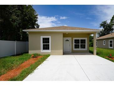 Tan single story home with a modern design, concrete driveway, and a well-maintained, landscaped yard at 144 Mandrake St, Orlando, FL 32811