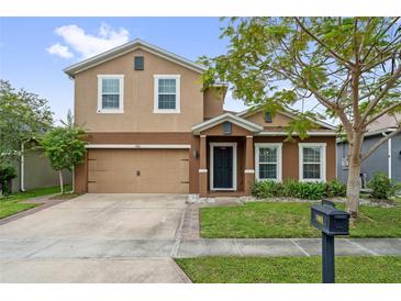 Charming two-story home with a well-maintained lawn, a two car garage, and beautiful landscaping at 1961 Continental St, St Cloud, FL 34769