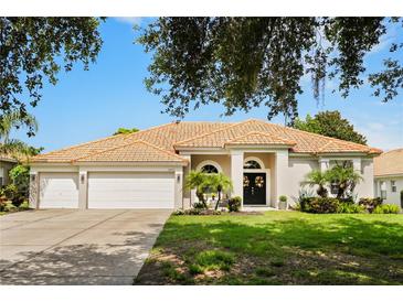 Charming one-story home featuring a well-manicured lawn, beautiful landscaping, and a double-door entrance at 6426 Montclair Bluff Ln, Windermere, FL 34786