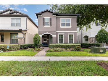 Charming two-story home with a landscaped front yard, inviting entrance, and neutral-colored exterior at 14215 Lakeview Park Rd, Winter Garden, FL 34787