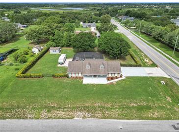 Expansive aerial view of a home showcasing a large lot, screened pool, RV, and mature trees at 15650 Catherine Cir, Groveland, FL 34736