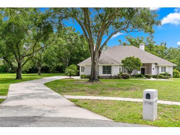 Stunning single-story home with a lush front yard, mature trees, and long driveway at 1700 Shandwick Ct, Longwood, FL 32779