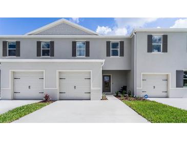 Charming townhome featuring a two-car garage and neutral-toned exterior with decorative shutters at 3298 Wye Oak Dr, Apopka, FL 32703