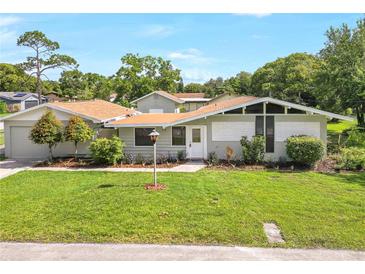 Charming single-story home featuring a well-manicured lawn and mature landscaping at 338 Eastern Ave, St Cloud, FL 34769