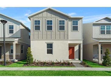 Charming two-story home featuring light gray siding, red front door, and well-maintained landscaping at 494 Belmond Dr, Debary, FL 32713