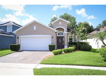 Charming single-story home featuring a well-manicured lawn, paved driveway, and attached two-car garage at 4954 Alavista Dr, Orlando, FL 32837