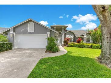 Charming home with a two-car garage, manicured lawn, and colorful landscaping enhancing its curb appeal at 651 Oak Hollow Way, Altamonte Springs, FL 32714
