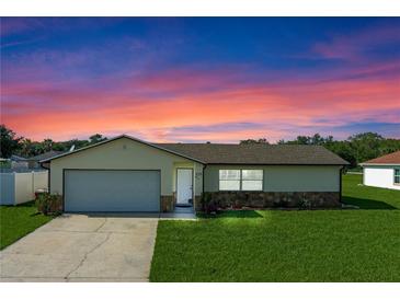 Charming single-story home with a well-maintained lawn and attached two-car garage at dusk at 856 Mendoza Dr, Kissimmee, FL 34758