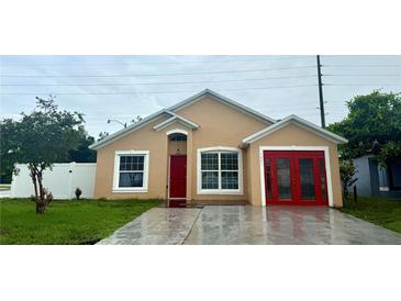 Charming single-story home with a well-maintained lawn and bright red front door at 1001 Golfside Ct, Kissimmee, FL 34741