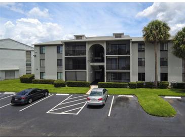 Exterior of the condo featuring a parking lot and well-maintained landscaping at 1221 S Pine Ridge Cir # A2, Sanford, FL 32773