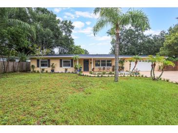 Charming single-story home featuring a well-manicured lawn and decorative palm trees for added curb appeal at 1405 Montclair Ct, Orlando, FL 32812