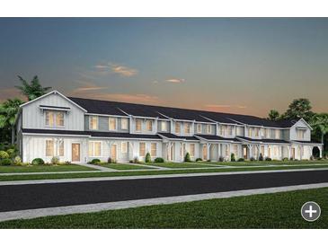 Row of townhomes in a planned community featuring modern farmhouse architecture and well-manicured lawns at 2349 Southbury Dr, Kissimmee, FL 34744