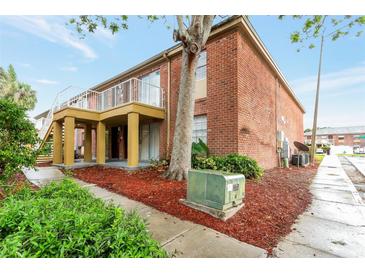 Brick apartment building with a balcony and a landscaped ground and large tree at 2520 Caper Ln # 206, Maitland, FL 32751