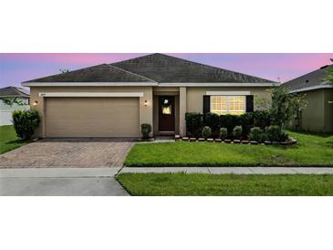 Charming single-story home with brick driveway and manicured lawn and a two car garage at 267 Williamson Dr, Davenport, FL 33897