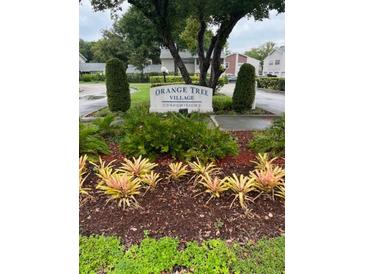 Well-manicured flower garden surrounding the Orange Tree Village Condominiums sign at 2776 Curry Ford Rd # Ge, Orlando, FL 32806